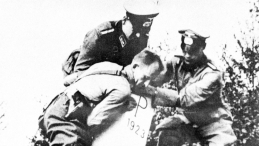 Reprodukcja: inwazja Niemiec na Polskę we wrześniu 1939 r., żołnierze niemieccy obalają słup graniczny. Fot. PAP/Reprodukcja