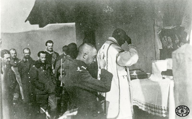 Oficerowie Polskiego Korpusu Posiłkowego uczestniczą w niedzielnym nabożeństwie. Obóz internowanych w Huszt, Węgry. 1918 r. Źródło: CAW