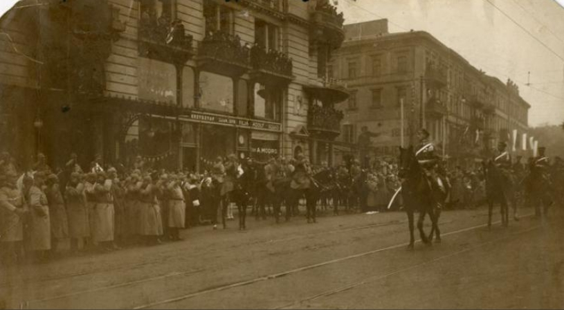 Na Krakowskim Przedmieściu defilada 2. Pułku Ułanów. Salutują oficerowie niemieccy (z lewej). Źródło: CAW
