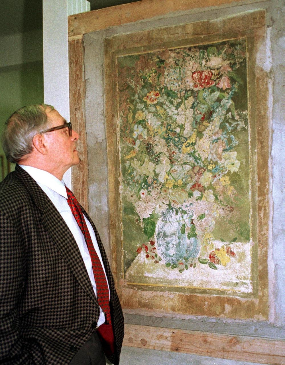Józef Szajna stoi przed obrazem, który namalował na tynku jako więzień obozu koncentracyjnego Buchenwald. Fot. PAP/DPA