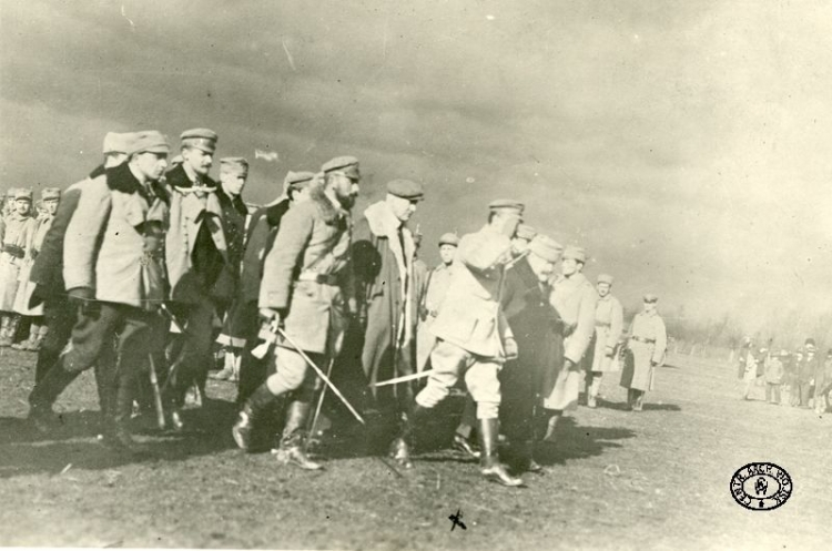 Komendant Józef Piłsudski (salutuje) udaje się ze swym sztabem na uroczystość dekoracji medalem legionistów. Obok mjr Edward Rydz ps. „Śmigły” (z brodą). Kęty. 14.02.1915 r. Źródło: CAW.jpg