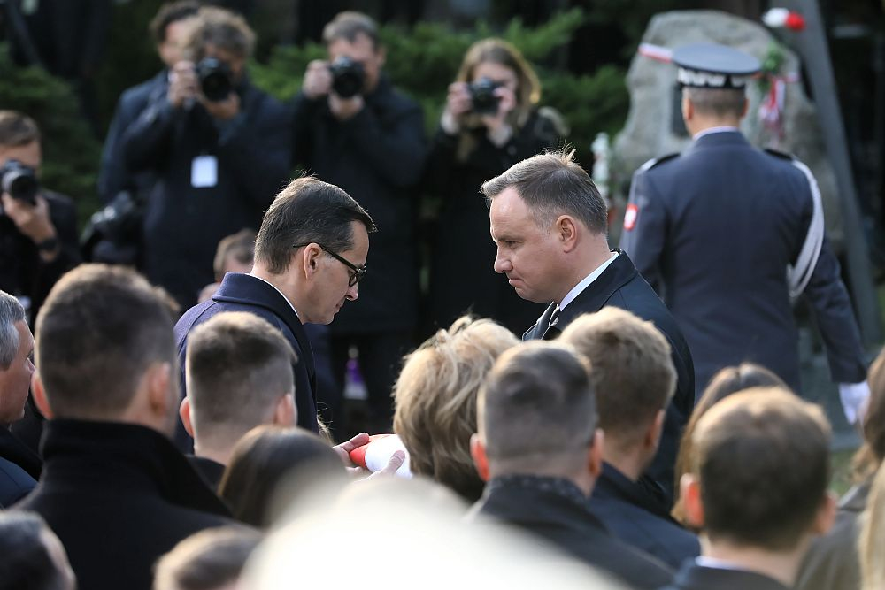 Pogrzeb marszałka seniora Kornela Morawieckiego na Powązkach Wojskowych w Warszawie. Po wystąpieniach rodziny i przyjaciół zmarłego prezydent Andrzej Duda (P) przekazał flagę leżącą na trumnie premierowi Mateuszowi Morawieckiemu. 05.10.2019. Fot. PAP/R. Guz