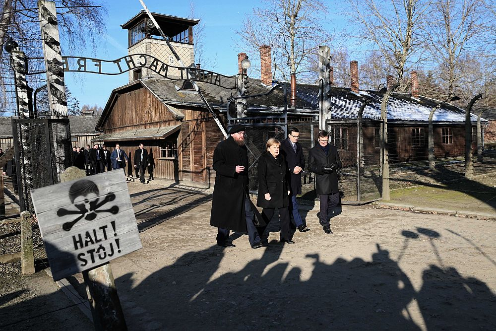 Kanclerz Niemiec Angela Merkel (2L), premier Mateusz Morawiecki (2P), dyrektor Państwowego Muzeum Auschwitz-Birkenau Piotr Cywiński (L) i wicedyrektor Państwowego Muzeum Auschwitz-Birkenau Andrzej Kacorzyk (P) na terenie byłego niemieckiego nazistowskiego obozu zagłady Auschwitz. Fot. PAP/A. Grygiel