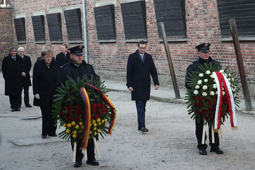 Kanclerz Niemiec Angela Merkel (3L) oraz premier Mateusz Morawiecki (2P) składają kwiaty przy Ścianie Straceń na terenie byłego niemieckiego nazistowskiego obozu zagłady Auschwitz. Fot. PAP/Ł. Gągulski