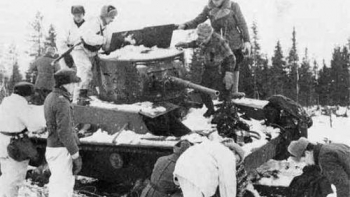  Fińscy żołnierze przy porzuconym podczas Wojny Zimowej sowieckim czołgu T-26. Styczeń 1940 r. Fot. Wikimedia Commons