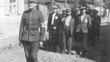 Litewski policjant prowadzący grupę żydowskich robotników. Wilno, 1941 r. Źródło: Wikimedia Commons/Bundesarchiv