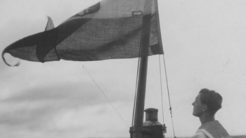 Marynarz wciąga banderę na maszt torpedowca ORP "Kujawiak". 1924-1936. Źródło: NAC