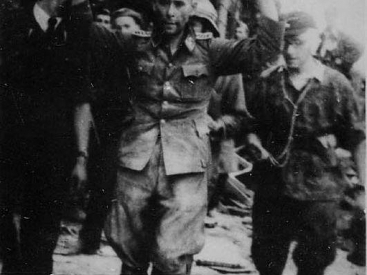 Jeniec niemiecki prowadzony przez powstańców. 21.08.1944 r. Źródło: CAW