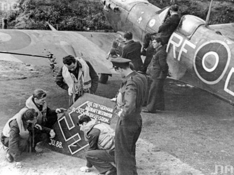 Lotnicy polskiego Dywizjonu 303 oglądają szczątki zestrzelonego samolotu niemieckiego Ju 88. 1941 r. Fot. NAC