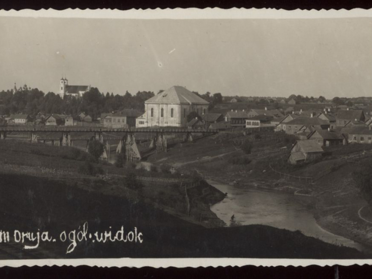 Druja. Widok od strony rzeki Drujki. Na pierwszym planie synagoga, w głębi widoczny kościół w Przydrujsku  Pocztówka 1936 r. Źródło: BN Polona