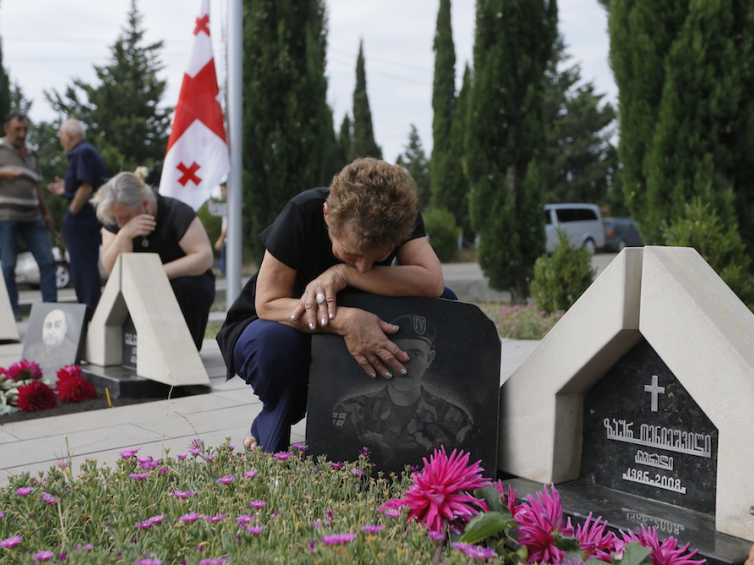 Kobieta przy grobie poległego żołnierza podczas ceremonii składania wieńców na cmentarzu w Tbilisi. Fot. PAP/EPA