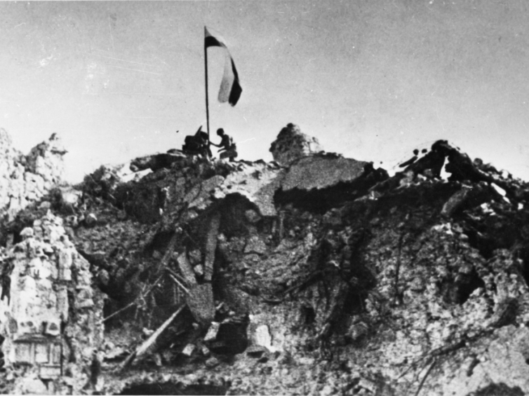 Monte Cassino 18.05.1944. Po trzygodzinnej, zwycięskiej walce, patrol z 12. Pułku Ułanów Podolskich zatyka polską flagę nad rumowiskiem klasztoru Monte Cassino. mo PAP/CAF