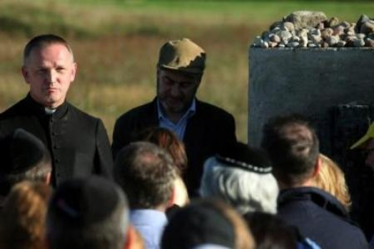 Piotr Kadlcik oraz ksiądz Wojciech Lemański podczas spotkania pod pomnikiem. Jedwabne, 04.09.2011. Fot. PAP/T. Gzell 