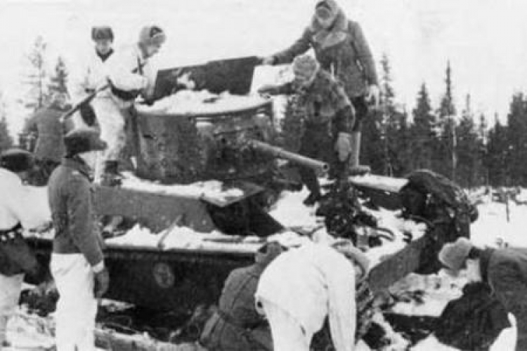 Fińscy żołnierze przy porzuconym podczas Wojny Zimowej sowieckim czołgu T-26. Styczeń 1940 r. Fot. Wikimedia Commons