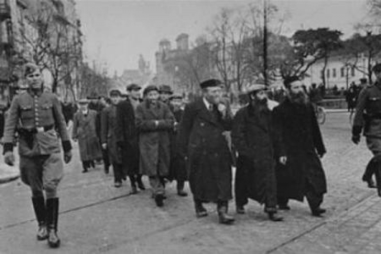 Żydzi eskortowani w drodze do pracy na Krakowskim Przedmieściu. Marzec 1940 r. Źródło: IPN