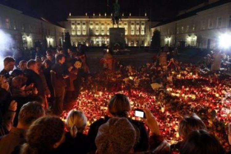 Przed Pałacem Prezydenckim ludzie składają kwiaty, zapalają znicze, modlą się za ofiary katastrofy. 10.04.2010. Fot. PAP