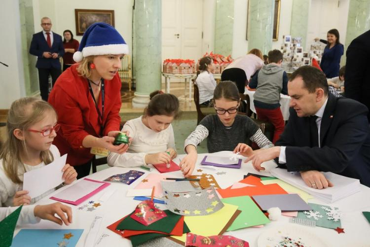 Szef gabinetu prezydenta Adam Kwiatkowski (P) razem z dziećmi przygotowywali w Pałacu Prezydenckim kartki świąteczne dla weteranów. Fot. PAP/P. Supernak