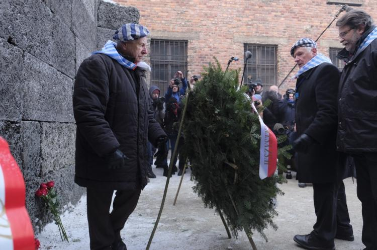 Byli więźniowie składają kwiaty i zapalają znicze pod Ścianą Śmierci, przy bloku 11 byłego obozu Auschwitz I, w trakcie obchodów 72. rocznicy wyzwolenia niemieckiego obozu zagłady KL Auschwitz-Birkenau. Fot. PAP/A. Grygiel