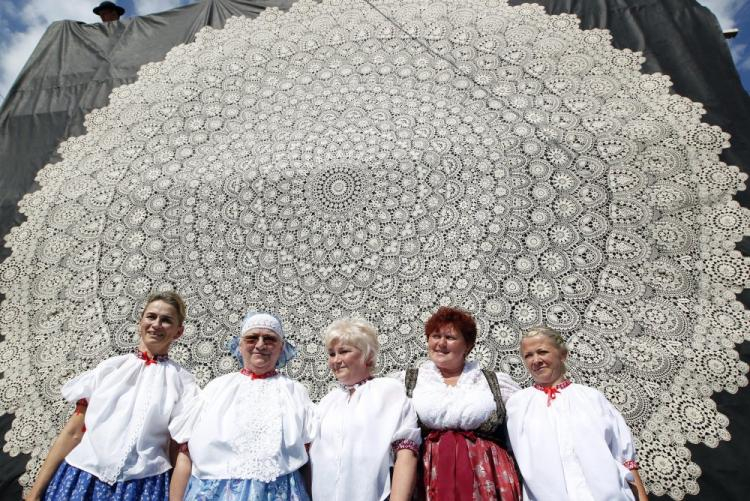 Koronka "Rózia" (5 metrów średnicy, 5 kg wagi) i twórczynie dzieła, mieszkanki Koniakowa: Marta Haratek (2L), Urszula Rybka (2P), Renata Krasowska (L), Danuta Krasowska (C) i Mariola Legierska (P). Koniaków, 2013 r. Fot. PAP/A. Grygiel 