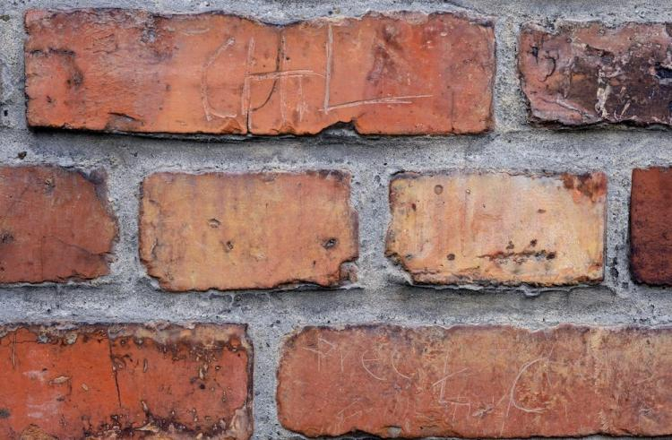 Fragment bramy obozu Auschwitz II-Birkenau, na której dwaj Portugalczycy próbowali wyryć swoje imiona i nazwiska. Fot. PAP/A. Grygiel