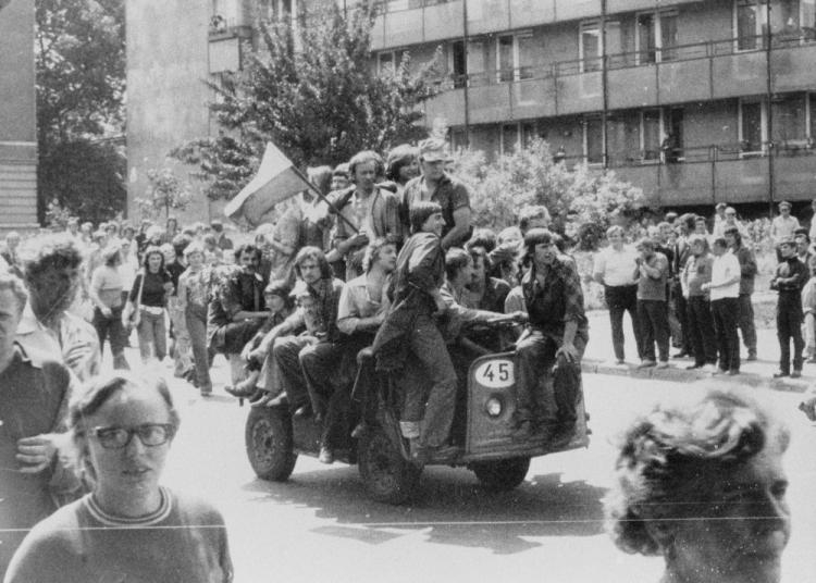 Radomski Czerwiec 1976 - grupa młodych ludzi jadących akumulatorowym wózkiem z narodową flagą przed gmach KW PZPR. 25.06.1976. Fot. PAP/CAF/Reprodukcja