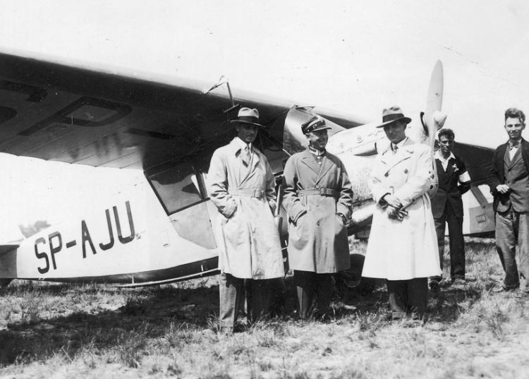 Stanisław Skarżyński (w środku) w towarzystwie inżyniera Stanisława Rogalskiego (na prawo od kpt. Skarżyńskiego) oraz Jerzego Wędrychowskiego (na lewo od kpt. Skarżyńskiego) przed samolotem RWD-5 bis o numerze rejestracyjnym SP-AJU. Źródło: NAC