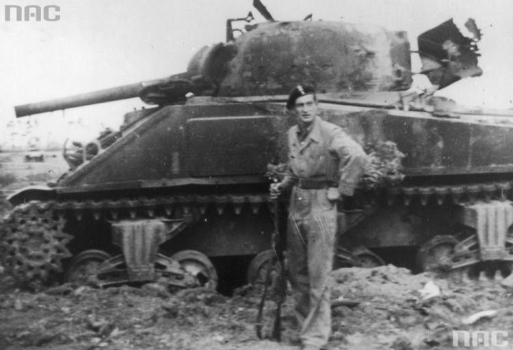 Bitwa pod Falaise. Żołnierz 1 Dywizji Pancernej obok zniszczonego kanadyjskiego czołgu. Fot. NAC