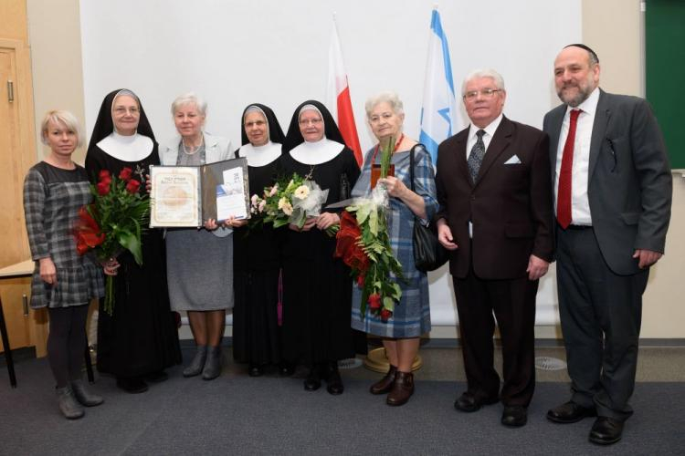 Naczelny rabin Polski Michael Schudrich (P), Jan Budnowski (2P), Krystyna Kabat (3P) i ich bliscy z medalem dla Tekli Budnowskiej. Fot. PAP/J. Kaczmarczyk