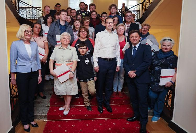 Premier Mateusz Morawiecki (4P), rzecznik rządu Joanna Kopcińska (L), szef KPRM Michał Dworczyk (2P) pozują do zdjęcia ze zwiedzającymi KPRM w ramach Nocy Muzeów. Fot. PAP/L. Szymański