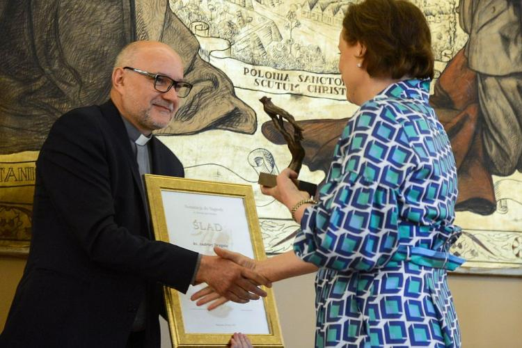 Laureat Nagrody Dziennikarskiej "Ślad" im. Biskupa Jana Chrapka ks. Andrzej Draguła odbiera wyróżnienie z rąk publicystki Ewy Czaczkowskiej. Fot. PAP/J. Kamiński