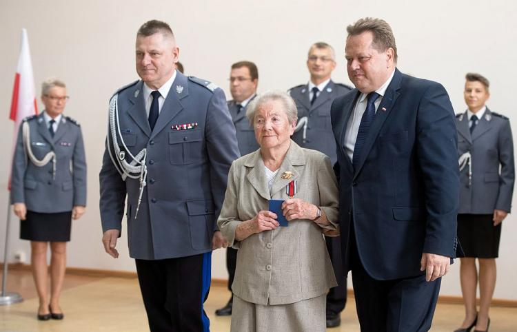 Wyróżniona Złotym Medalem Za Zasługi dla Policji Zofia Matias oraz wiceminister spraw wewnętrznych i administracji Jarosław Zieliński (P) i zastępca Komendanta Głównego Policji nadinsp. Jan Lach. Fot. PAP/G. Michałowski