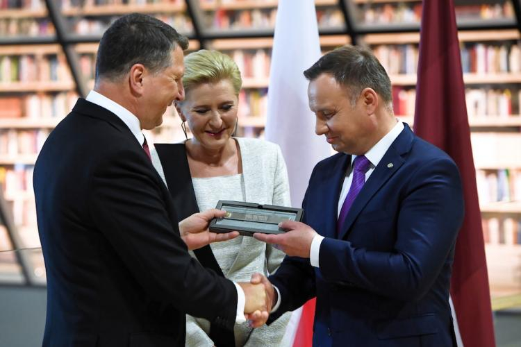 Prezydent RP Andrzej Duda (P) z żoną Agatą Kornhauser-Dudą (C) oraz prezydent Republiki Łotweskiej Raimonds Vejonis (L) podczas przekazania przez prezydenta RP okolicznościowego upominku dla łotewskiej Biblioteki Narodowej, z okazji obchodzonej w tym roku setnej rocznicy niepodległości kraju, 27 bm. w Rydze. Fot. PAP/R. Pietruszka