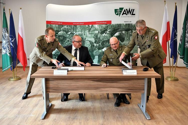 Dyrektor oddziału IPN Wrocław dr Andrzej Dragoń (2L) i rektor AWL gen. bryg. Dariusz Skorupka (2P) podczas podpisania umowy o współpracy pomiędzy Akademią Wojsk Lądowych i Instytutem Pamięci Narodowej. Fot. PAP/M. Kulczyński