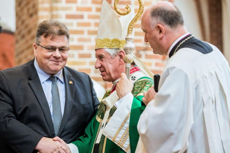 Uroczyste obchody 85. rocznicy lotu przez Atlantyk litewskich pilotów Steponasa Dariusa i Stasysa Girenasa - minister spraw zagranicznych Litwy Linas Antanas Linkevicius (L) odznacza "Gwiazdą Dyplomacji Litwy" abp. Andrzeja Dzięgę (C), po mszy świętej w Katedrze św. Jakuba w Szczecinie. Fot. PAP/J. Muszyński