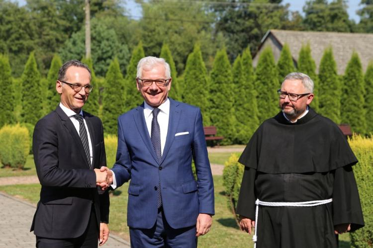 Harmęże (woj. małopolskie), 20.08.2018. Ministrowie spraw zagranicznych, Polski Jacek Czaputowicz (C), Niemiec Heiko Maas (L) i gwardian o. Piotr Cuber (P) podczas powitania przed spotkaniem przy wejściu do Centrum św. Maksymiliana w miejscowości Harmęże koło Oświęcimia. Fot. PAP/A. Grygiel