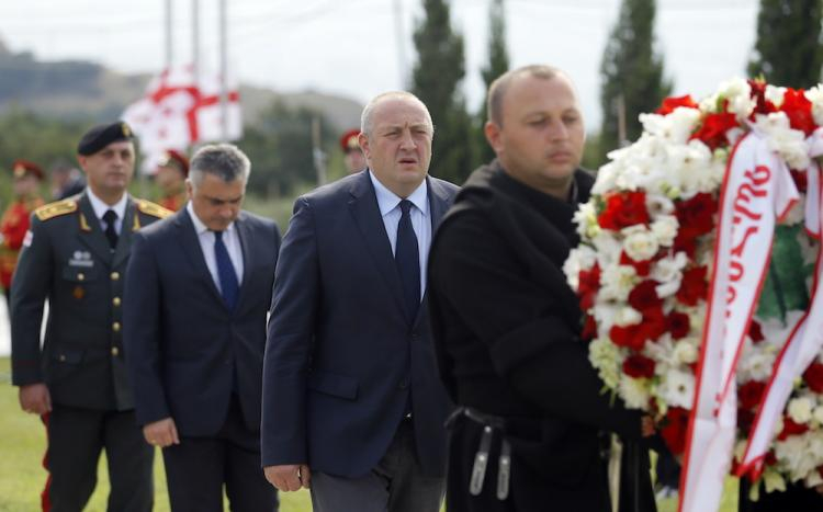 Gruziński prezydent Giorgi Margvelashvili (C) uczestniczy w uroczystości składania wieńców na cmentarzu w Tbilisi. Oficjalna ceremonia odbyła się tutaj z okazji dziesiątej rocznicy konfliktu rosyjsko-południowoosetyjsko-gruzińskiego. Fot. PAP/EPA