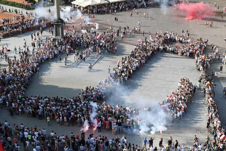 Mieszkańcy Warszawy tworzą "żywy znak" Polski Walczącej, 1 bm. na placu Zamkowym w ramach obchodów 74. rocznicy wybuchu Powstania Warszawskiego. Fot. PAP/M. Kmieciński