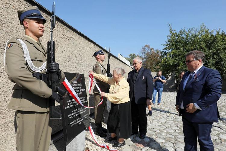 Janina Zielińska, inicjatorka upamiętnienia i dziecko Zamojszczyzny (C), sekretarz stanu w Kancelarii Prezydenta RP Andrzej Dera (P), dyrektor muzeum Tadeusz Skoczek (2P) podczas uroczystego odsłonięcia tablicy upamiętniającej dzieci z Zamojszczyzny na terenie warszawskiego Muzeum Więzienia Pawiak. Fot. PAP/P. Supernak