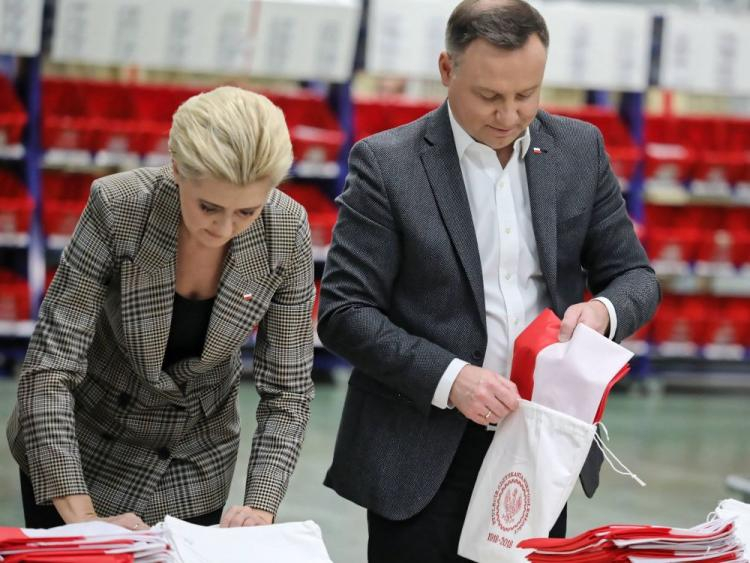 Prezydent Andrzej Duda z małżonką Agatą Kornhauser-Dudą wzięli udział w akcji pakowania i wysyłki flag państwowych na terenie węzła ekspedycyjno-rozdzielczego Poczty Polskiej w Warszawie. Fot. PAP/T. Gzell