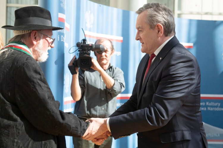 Wicepremier, minister kultury Piotr Gliński (P) wręczył projektantowi mody Jerzemu Antkowiakowi (L) w siedzibie Filharmonii Łódzkiej. Fot. PAP/G. Michałowski