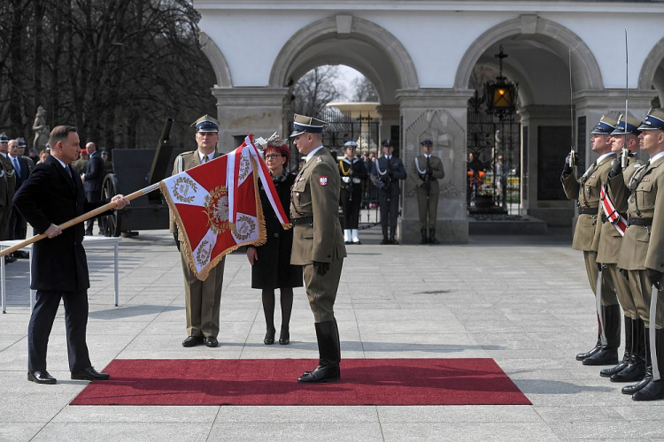 Prezydent Andrzej Duda (L) oraz dowódca Pułku Reprezentacyjnego Wojska Polskiego ppłk Leszek Szcześniak (C) podczas uroczystości wręczenia sztandaru wojskowego Pułkowi. Fot. PAP/P. Nowak