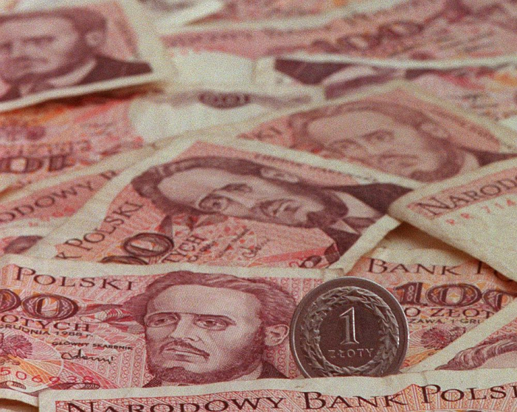Banknoty stuzłotowe sprzed denominacji i nowa moneta o nominale 1 zł. Fot. PAP/CAF/R. Pietruszka