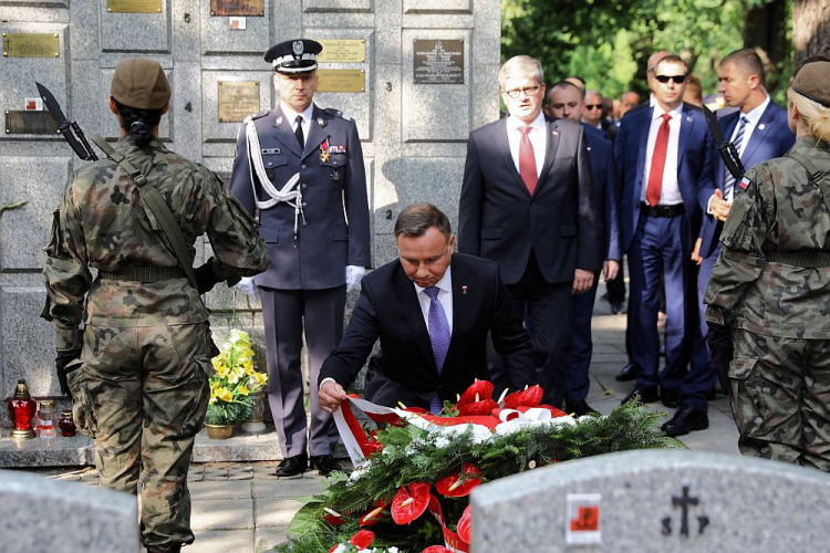 Prezydent Andrzej Duda (C), dowódca Garnizonu Warszawa gen. bryg. Robert Głąb (2L) i szef BBN Paweł Soloch (4L) składają kwiaty przed grobem gen. bryg. Antoniego Chruściela „Montera” na Cmentarzu Wojskowym na Powązkach w Warszawie. 01.08.2019. Fot. PAP/R. Guz