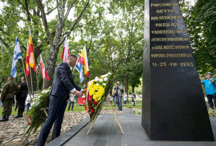 Wiceprezydent miasta Rafał Rudnicki (C) składa wieniec przed pomnikiem Bohaterów Getta na placu im. Mordechaja Tenenbauma. Fot. PAP/M. Zieliński