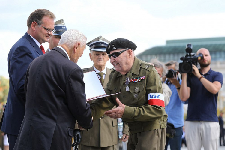 Weterani Narodowych Sił Zbrojnych mjr Bogdan Eubich (P) i mjr Stanisław Turski (2P) zostali odznaczeni medalem Pro Bono Poloniae. Przewodniczący Rady do Spraw Kombatantów i Osób Represjonowanych Bogusław Nizieński (2L) oraz szef Urzędu do Spraw Kombatantów i Osób Represjonowanych Jan Józef Kasprzyk (L). Obchody 75. rocznicy powstania Brygady Świętokrzyskiej NSZ na pl. Piłsudskiego w Warszawie. Fot. PAP/R. Guz