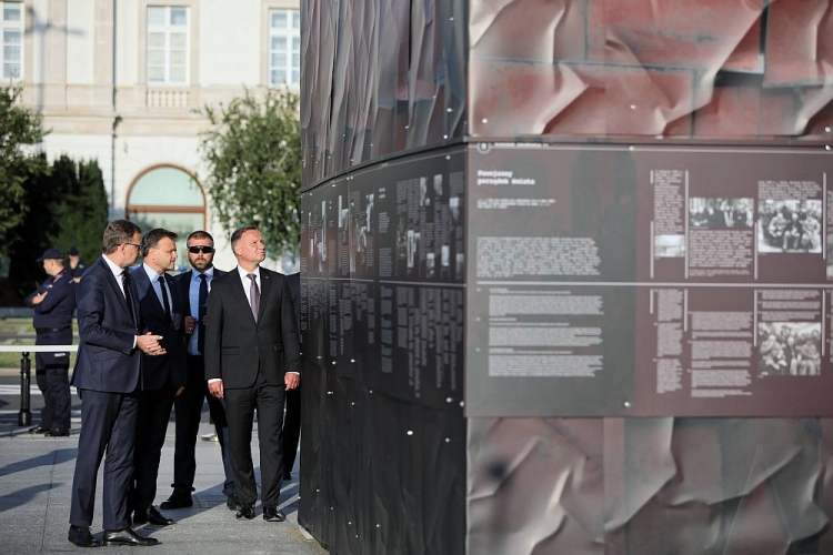 Prezydent Andrzej Duda (P) oraz prezes IPN Jarosław Szarek (L) podczas zwiedzania wystawy plenerowej „Ściany Totalitaryzmów. Polska 1939-1945” na pl. Piłsudskiego w Warszawie. Fot. PAP/L. Szymański