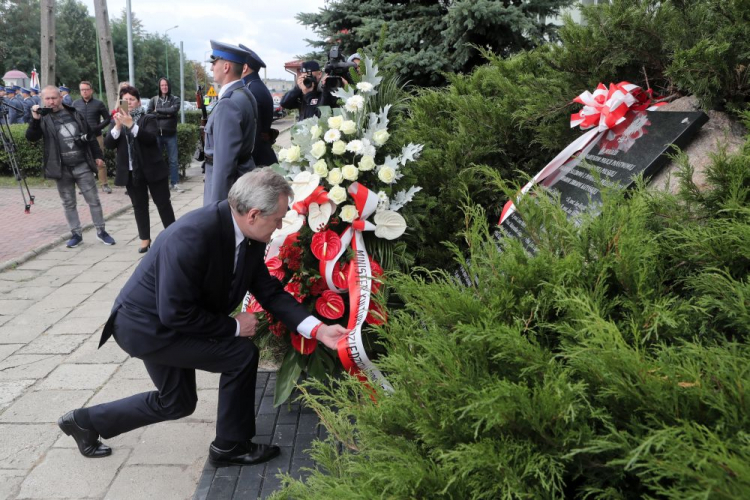 Brzeziny, 19.09.2019. Wicepremier, minister kultury i dziedzictwa narodowego Piotr Gliński składa kwiaty przed tablicą poświęconą pomordowanym funkcjonariuszom Policji Państwowej II RP. PAP/R. Zawistowski