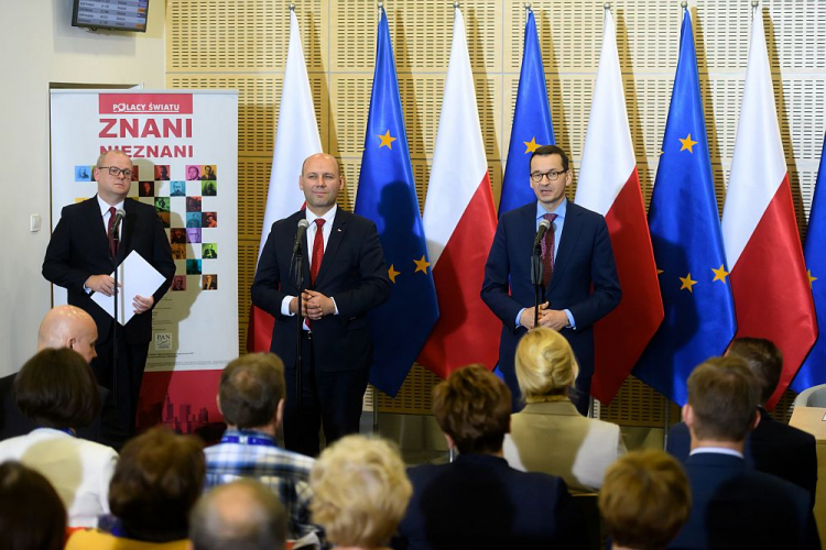 Premier Mateusz Morawiecki (P) oraz wiceminister spraw zagranicznych Szymon Szynkowski vel Sęk (C) podczas uroczystości podpisania porozumienia w sprawie udzielania pomocy repatriantom z Kazachstanu oraz prezentacji wystawy „Znani nieznani. Polacy światu” w Porcie Lotniczym „Ławica” im. H. Wieniawskiego w Poznaniu. Fot. PAP/J. Kaczmarczyk