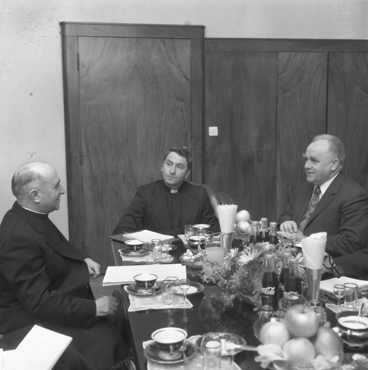 Warszawa 1977. Spotkanie przewodniczącego delegacji Watykanu do stałych kontaktów roboczych z PRL biskupa Luigi Poggi (L) z ministrem-kierownikiem Urzędu do Spraw Wyznań Kazimierzem Kąkolem (P) w siedzibie urzędu. Centralnie ksiądz Józef Kowalczyk. mta PAP/Andrzej Kossobudzki Orłowski Dokładny miesiąc i dzień wydarzenia nieustalone. Fot. PAP/A. Kossobudzki-Orłowski 