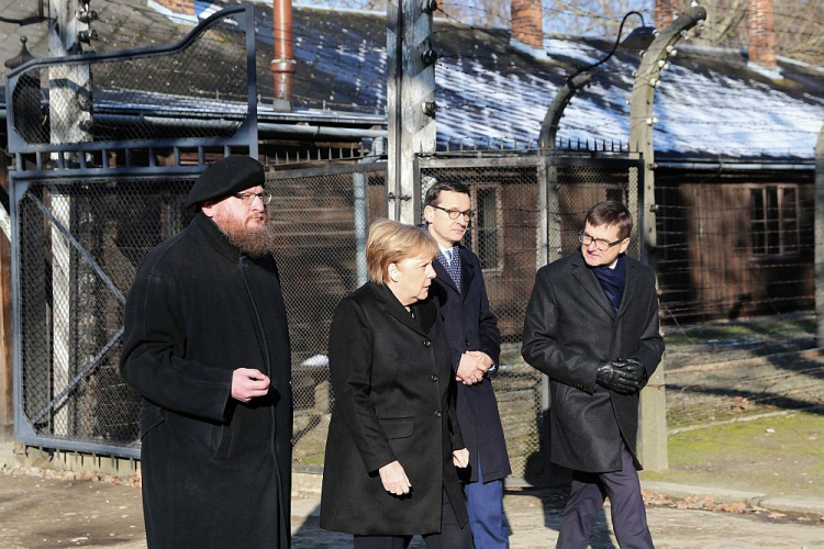 Kanclerz Niemiec Angela Merkel (2L), premier Mateusz Morawiecki (2P), dyrektor Państwowego Muzeum Auschwitz-Birkenau Piotr Cywiński (L) i wicedyrektor Państwowego Muzeum Auschwitz-Birkenau Andrzej Kacorzyk (P) na terenie byłego niemieckiego nazistowskiego obozu zagłady Auschwitz. Fot. PAP/A. Grygiel